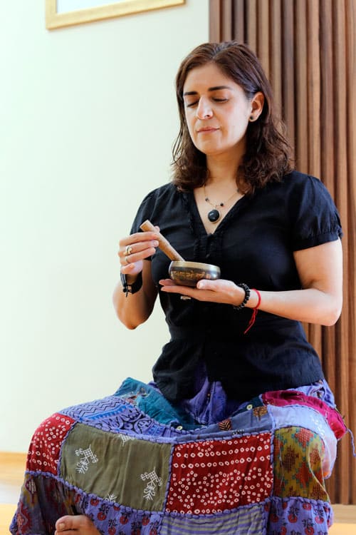 Maestra de Meditación Guiada con cuenco guiando clase en centro de bienestar Beyond Healing Center