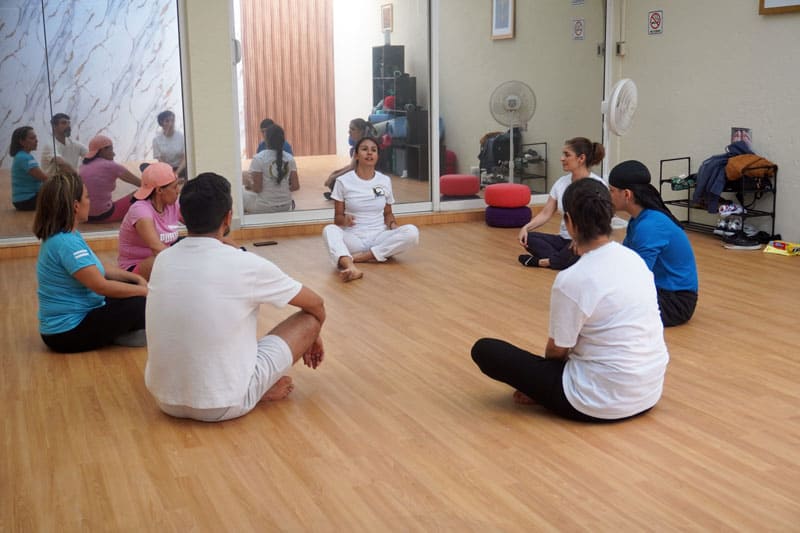 Coach dando paltica motivacional a alumnos para mejorar sus hábitos en centro de bienestar